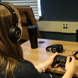 Games to Play Remotely. Photo of student with controller. Link to Games to Play Remotely